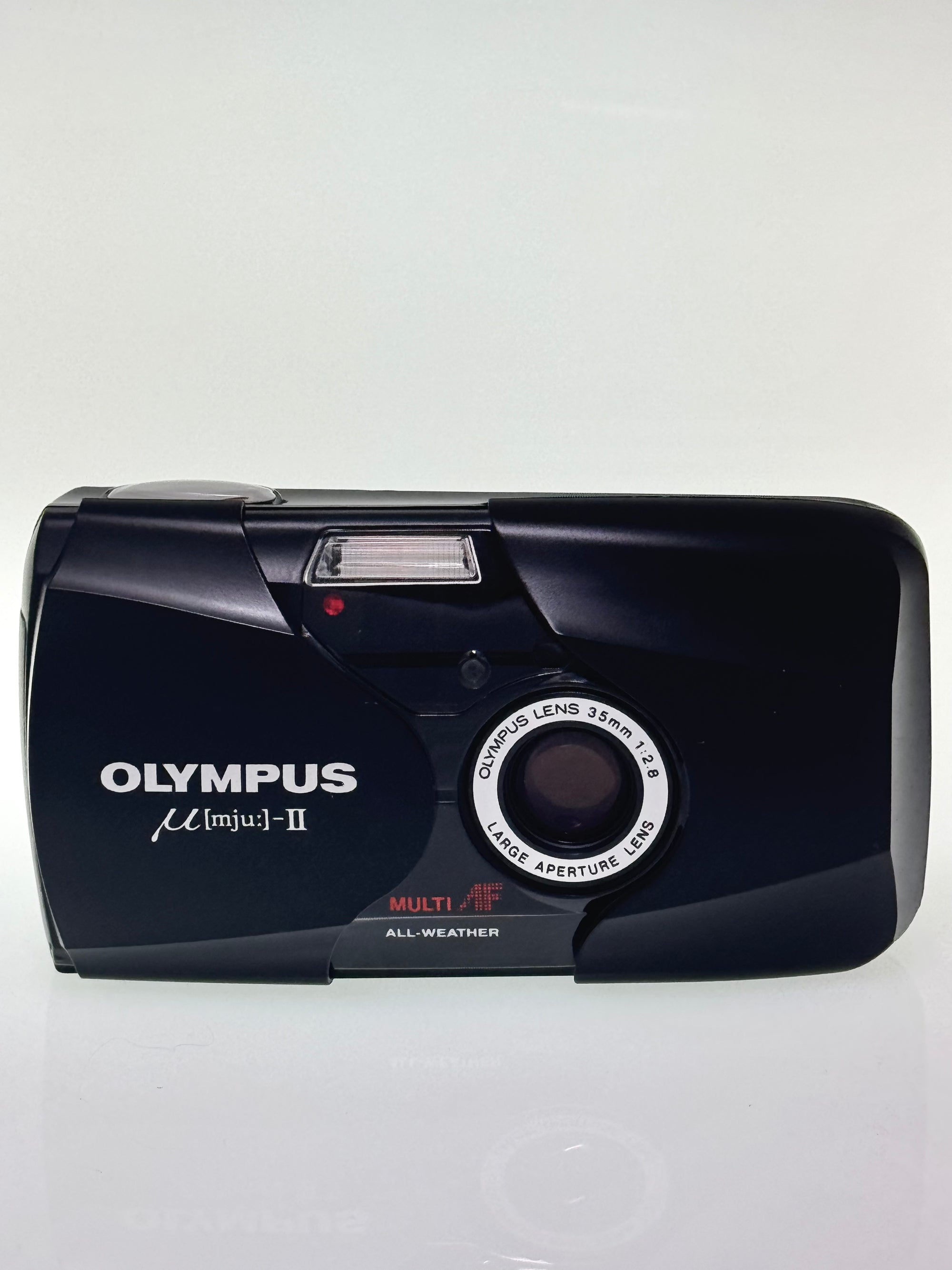 Black Olympus MJU 2 film camera on a white background