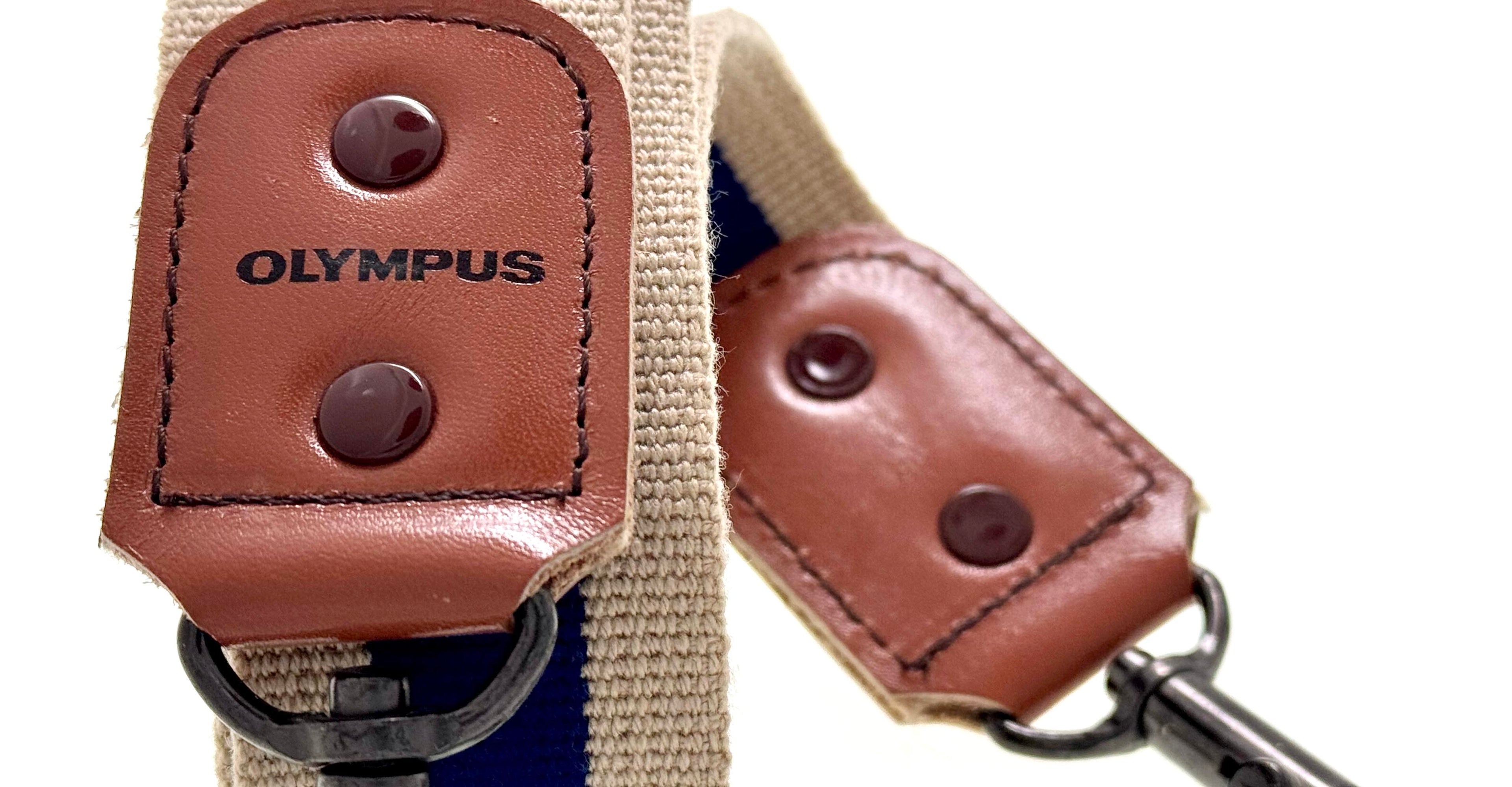 Brown leather strap with 'Olympus' branding on a white background